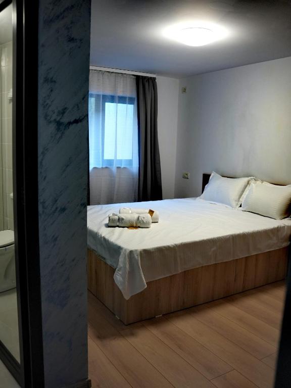 ein Schlafzimmer mit einem großen Bett, auf dem Handtücher liegen in der Unterkunft Defileu in Bumbeşti-Jiu