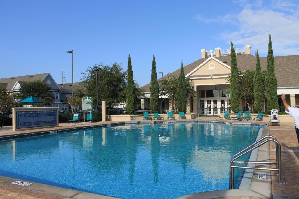 a large blue swimming pool with chairs and a building at Venetian Bay Villages Resort in Kissimmee