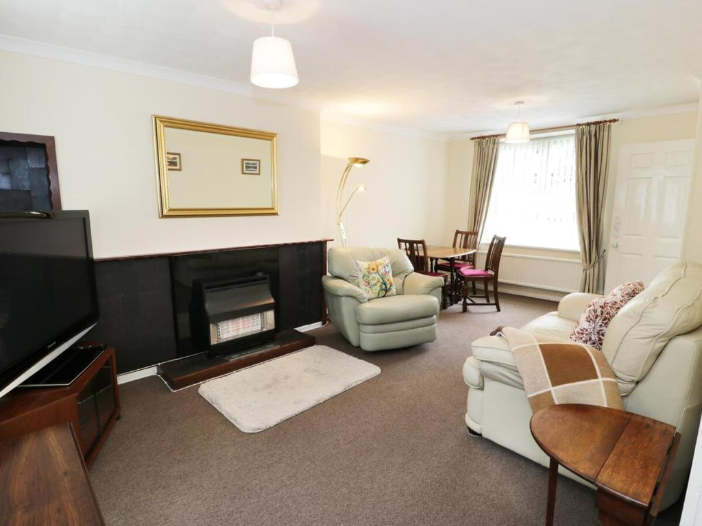 a living room with a couch and a fireplace at Cosy Snowdonia cottage, 3 bedrooms, near zip world and Snowdon in Blaenau-Ffestiniog