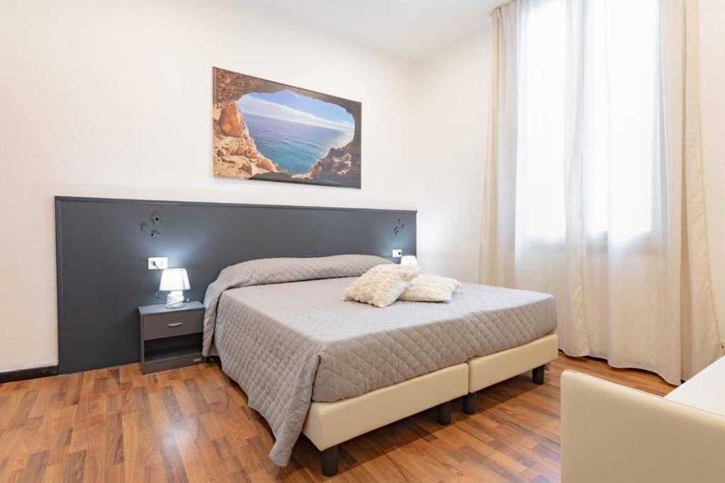 Un dormitorio con una cama y una ventana grande. en Hotel Victoria, en Finale Ligure