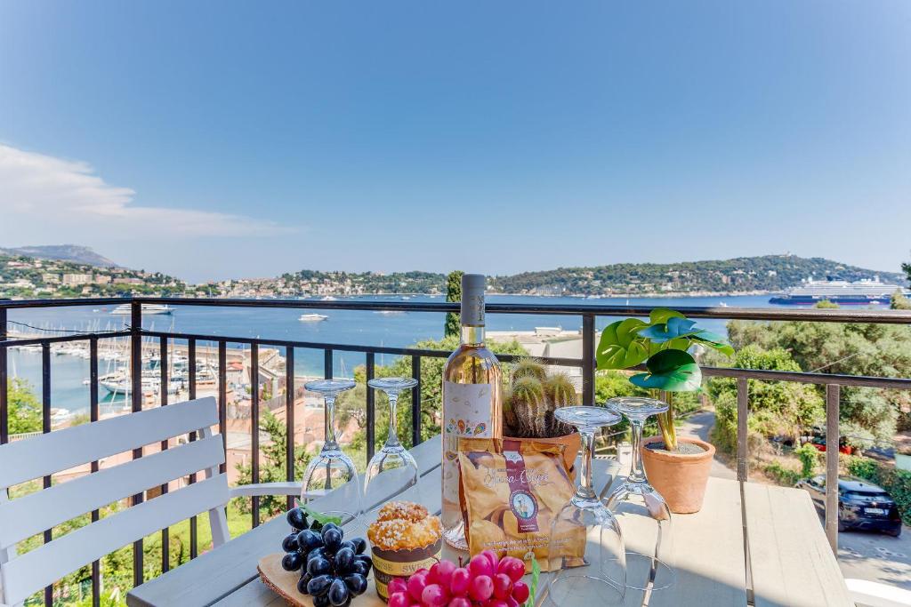 - une table avec des verres à vin et des fruits sur le balcon dans l'établissement BELLE DARSE AP4454 By Riviera Holiday Homes, à Villefranche-sur-Mer