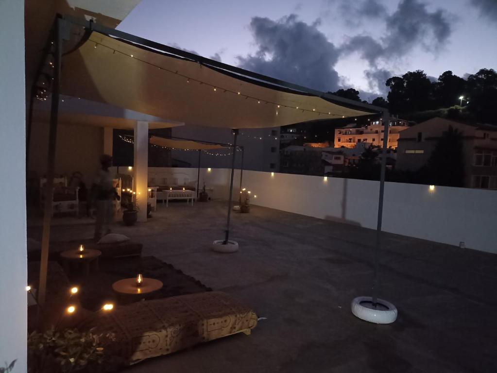 a rooftop patio with a canopy and lights at night at Le nid cosy in Tabarka