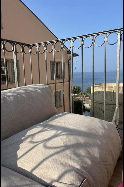 - un lit sur un balcon avec vue sur l'océan dans l'établissement Apartment in Ile Rousse with sea view, à LʼÎle-Rousse