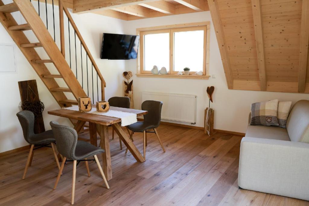 a living room with a table and chairs and a staircase at Heimatglück in Lautenbach