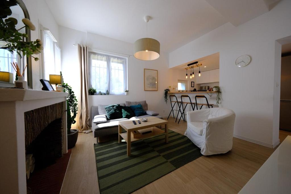 Proche Rouen - Magnifique T4 - 3 chambres في Déville-lès-Rouen: غرفة معيشة بها أريكة وطاولة