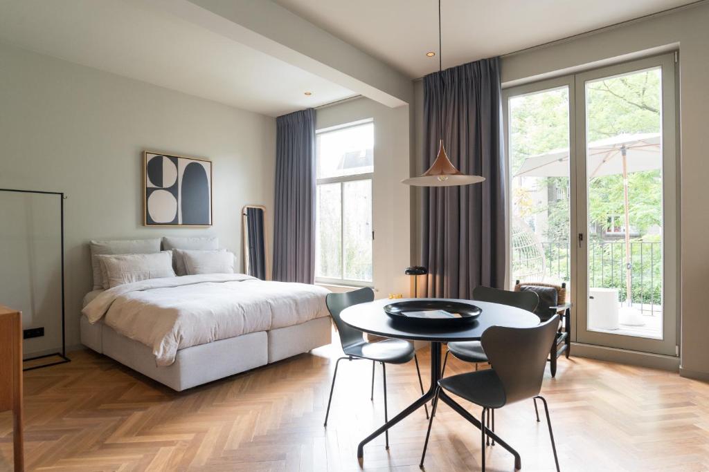 a bedroom with a bed and a table and chairs at Vondel 99 in Amsterdam