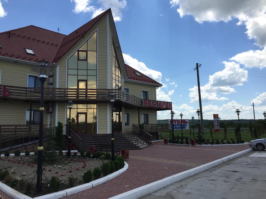 a yellow house with a porch and stairs on a street at Hotel Oktan in Kryve Ozero