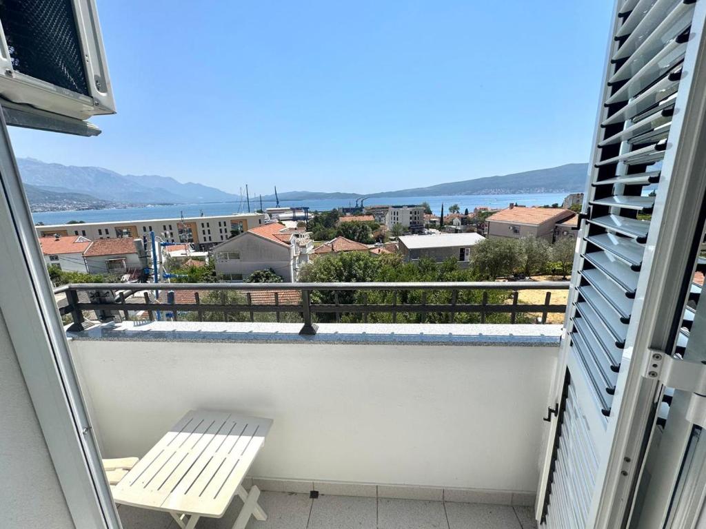 a balcony with a bench and a view of the ocean at Apartments Janda Bijela in Bijela