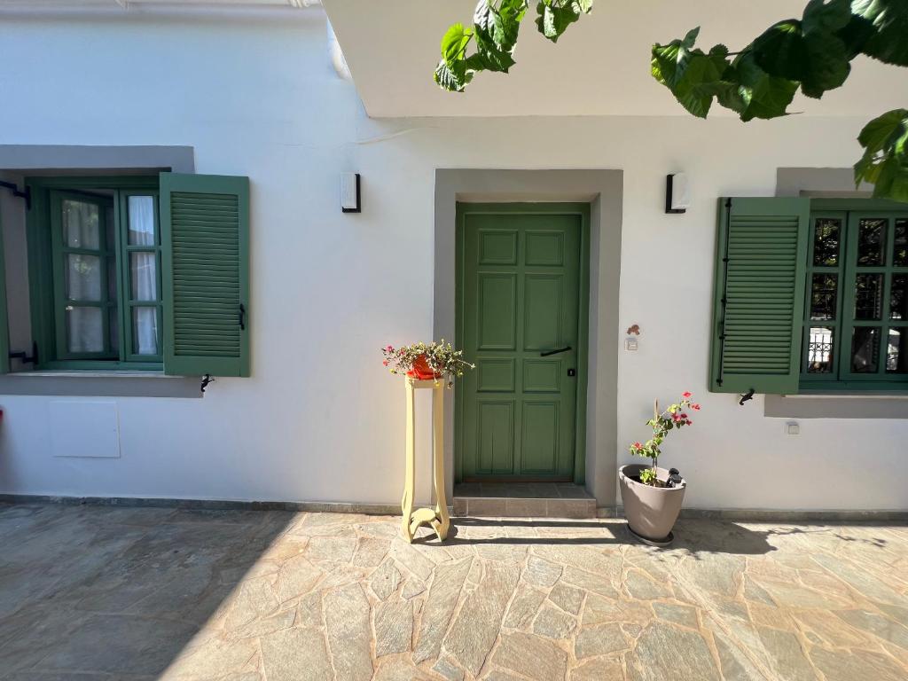 una porta verde su un edificio bianco con persiane verdi di Two houses and an arch - Ariadne and Aristeidis apartments a Rethymno