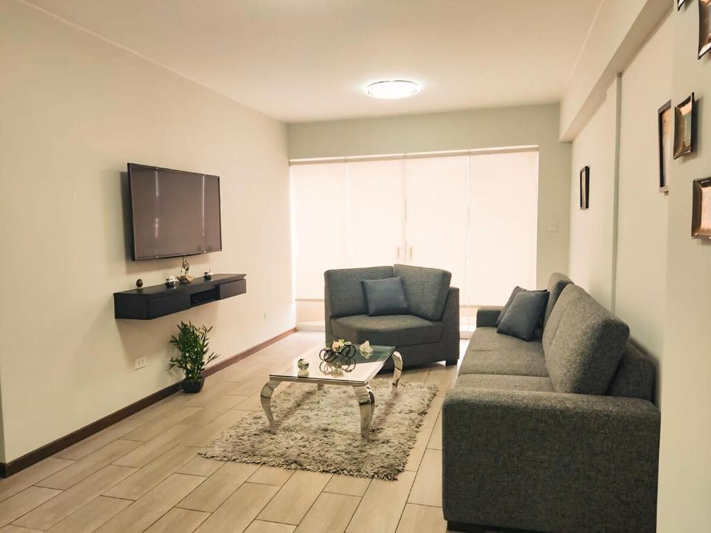 a living room with two chairs and a tv at Departamento amplio y céntrico-Terrazas in San Antonio