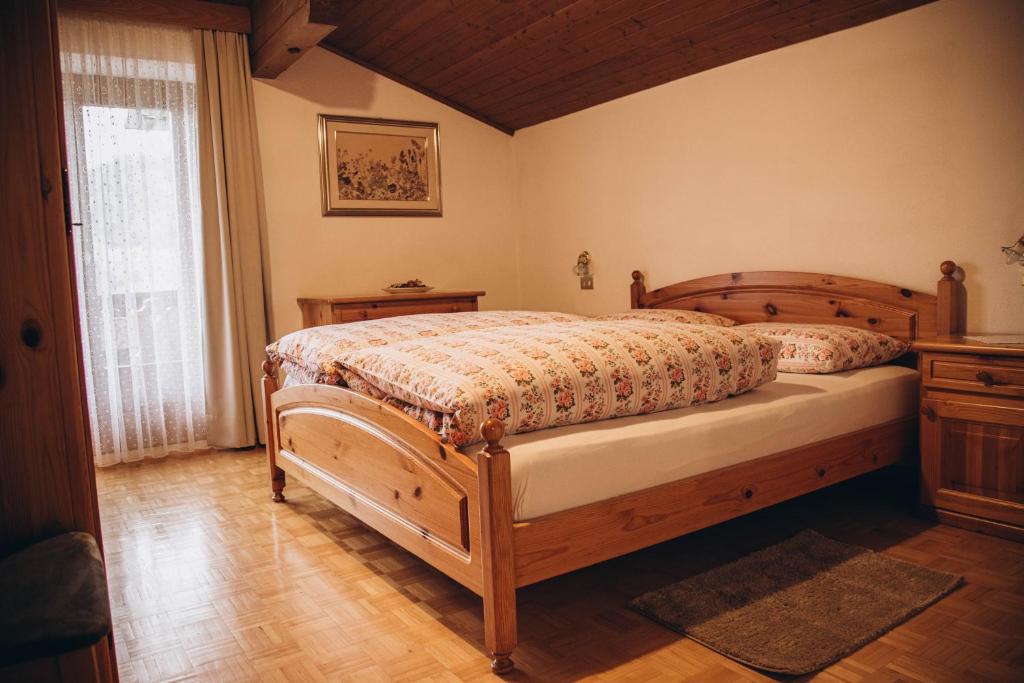 een slaapkamer met een houten bed en een raam bij Farm apartment I neni in Lovara