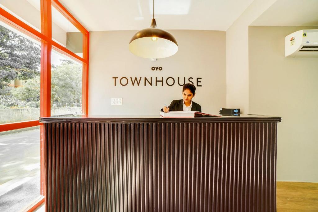 a woman sitting at a desk in an office at Townhouse Sarvar Hospitality Near Ascendas Park Square Mall in Bengaluru