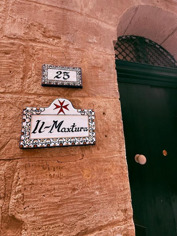 a street sign on the side of a building at Il-Maxtura - Charming 17th Century House Of Character in the Historical Three Cities in Cospicua