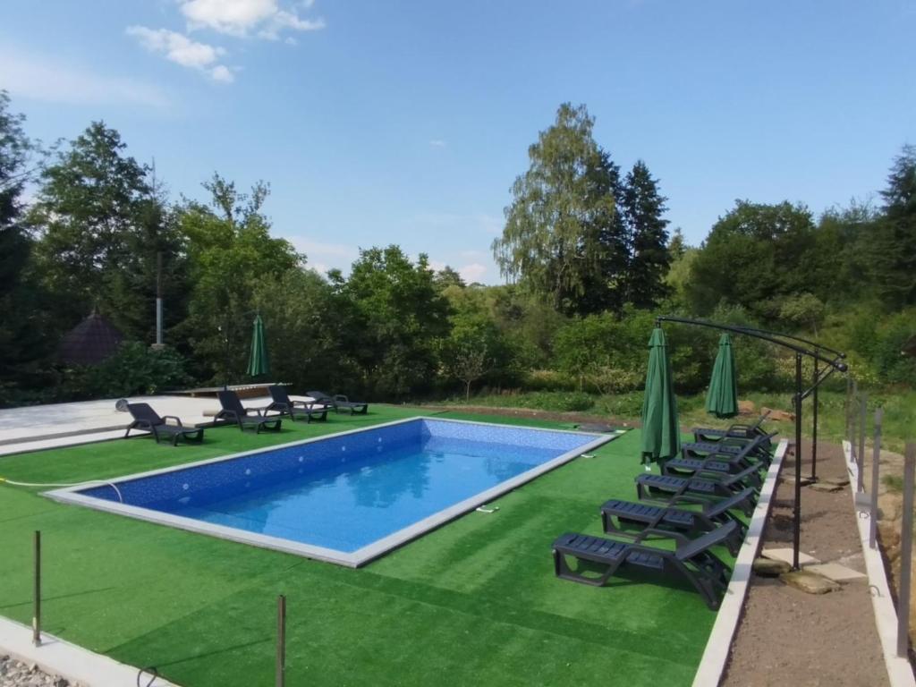 a swimming pool with lawn chairs and umbrellas at Goryanka in Yaremche