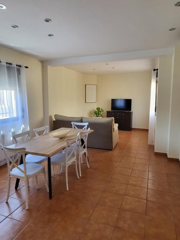 een woonkamer met een tafel, stoelen en een bank bij Pensión Dani in Casinos