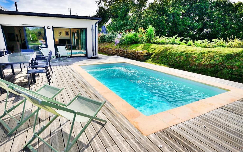- une piscine avec des chaises et une table sur une terrasse dans l'établissement Maison de Saint-Jean, à Fouesnant