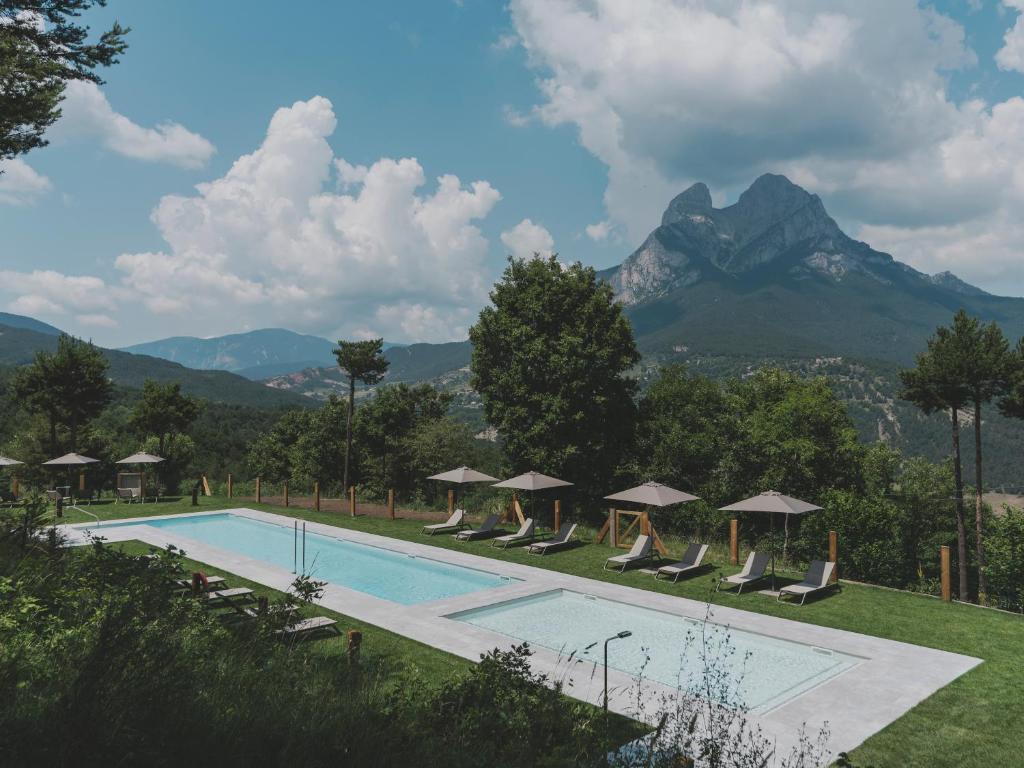 a resort swimming pool with mountains in the background at wecamp Pedraforca in Saldés
