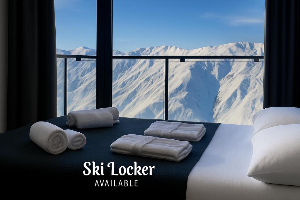 Una habitación con cama con toallas y vistas a las montañas. en VistaRest Gudauri Ski Resort - by VistaRest Escapes & Stays, en Gudauri