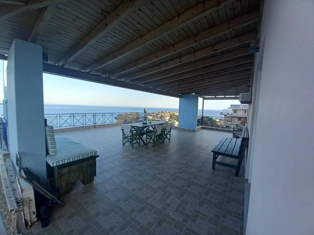 a balcony with a table and chairs and the ocean at The Big Blue in Gythio
