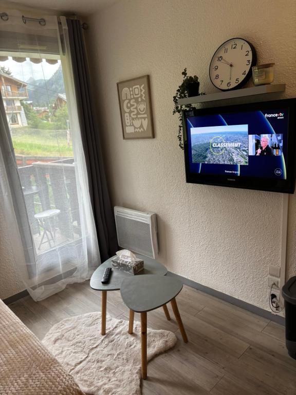 - un salon avec une télévision murale et une chaise dans l'établissement Studio cabine au pied des pistes, à Modane