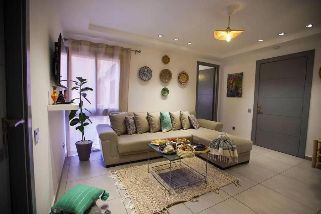 una sala de estar con un sofá y una mesa en Charming Cozy 2 Bedrooms central Gueliz, en Marrakech