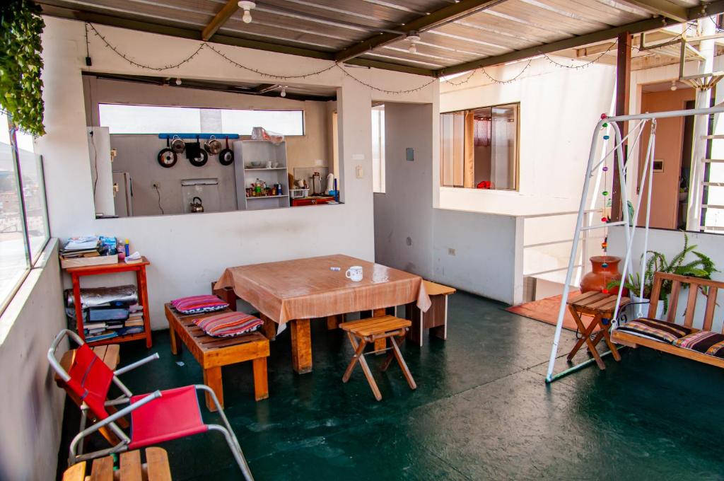 a room with a table and chairs and a kitchen at Hab Simple baño compartido Estudiante o Voluntario terraza vista a los Volcanes in Arequipa