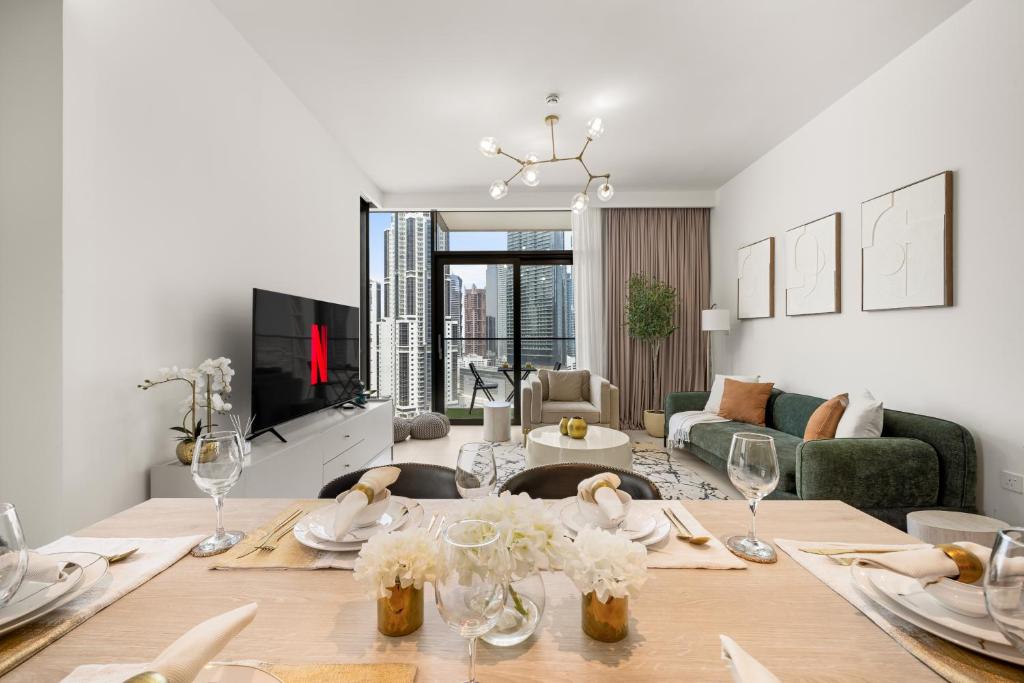 a living room with a table and a couch at Luxury Two Bedroom Apartment with City & Pool View by Delujo Stays in Dubai
