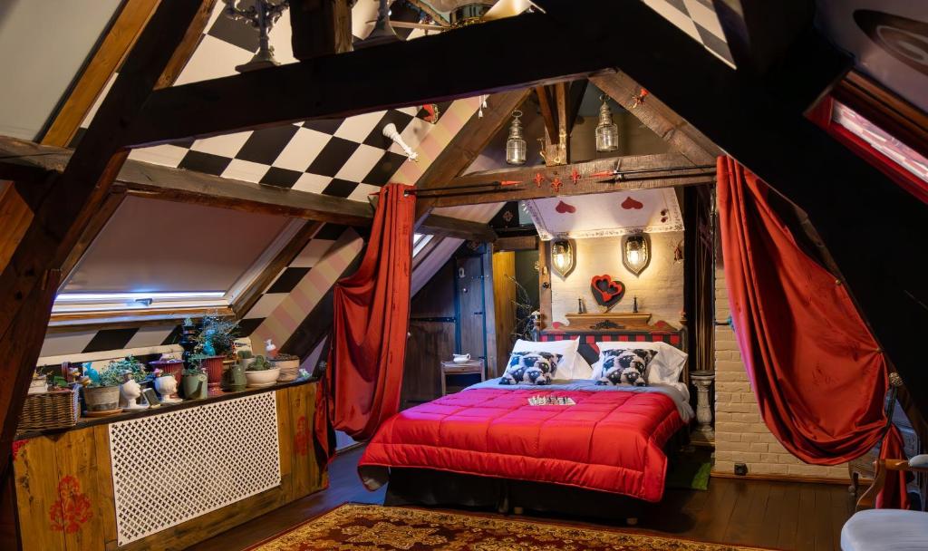 a bedroom with a red bed in a attic at Suivez Le Lapin Blanc-BB Chambres d'Hôtes in Saint-Valery-sur-Somme