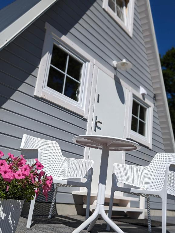 a table and chairs in front of a house at Domki Słodka Magnolia in Karwia