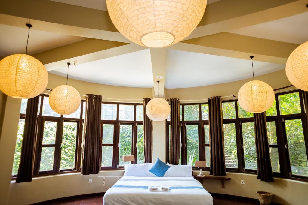 een slaapkamer met een bed en enkele verlichting en ramen bij Krazy Gecko Resort in Pokhara