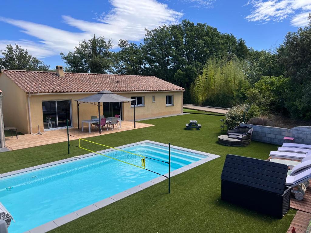 une cour arrière avec une piscine et une maison dans l'établissement Villa 4 chambres récente avec piscine et Jardin, à Lorgues