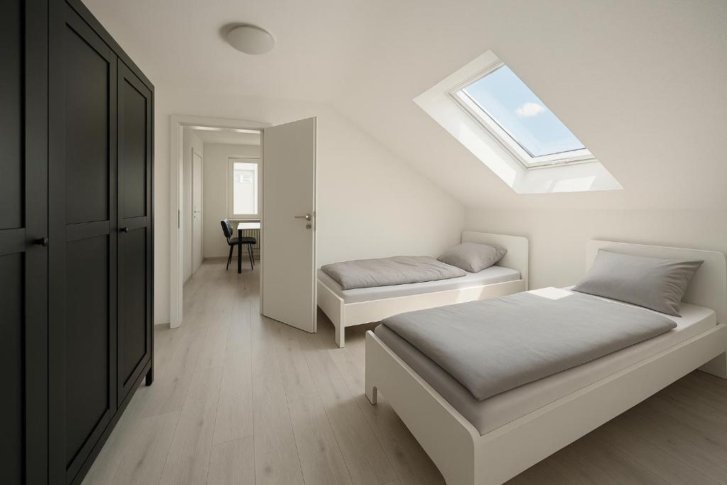 a bedroom with two beds and a skylight at Monteur- und Ferienwohnung Rheinhausen - Lönsweg in Oberhausen-Rheinhausen