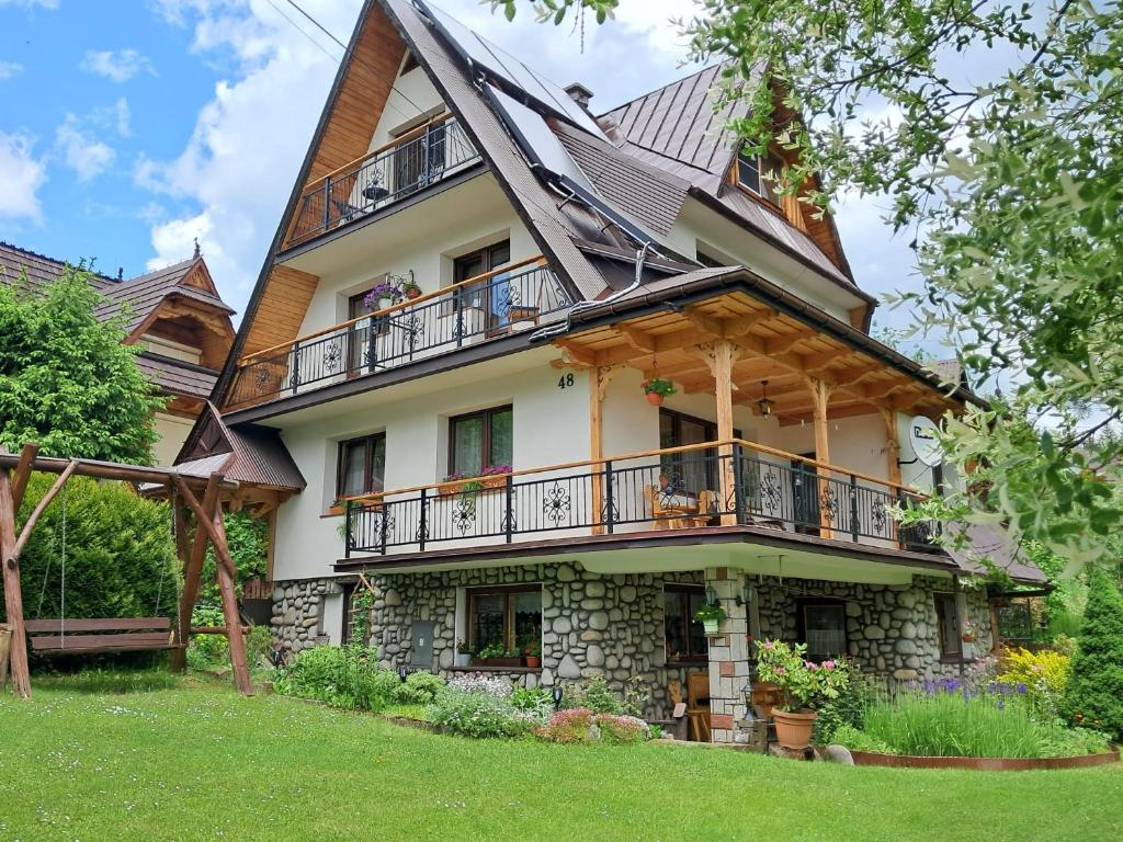 a large house with a porch and balcony at Pokój z balkonem 5 in Kościelisko