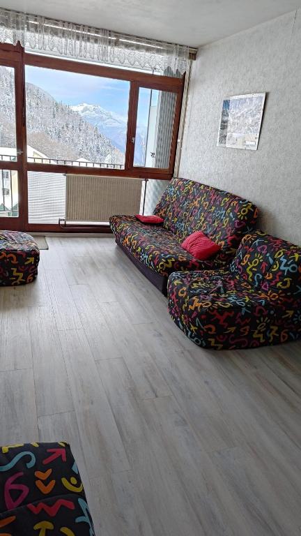 a living room with couches and a couch and a window at studio gourette pyrenees 4 pers pied des pistes in Gourette