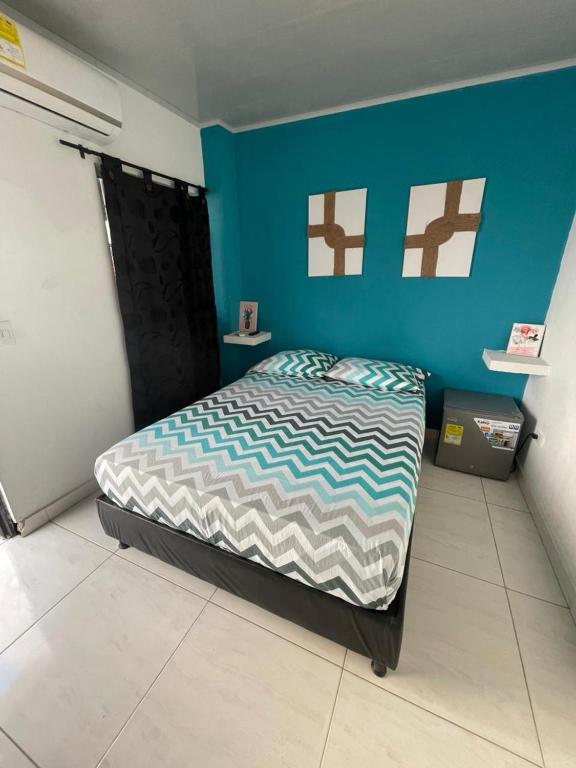 Un dormitorio con una cama y una pared azul. en Azul caribe 101, en Santa Marta