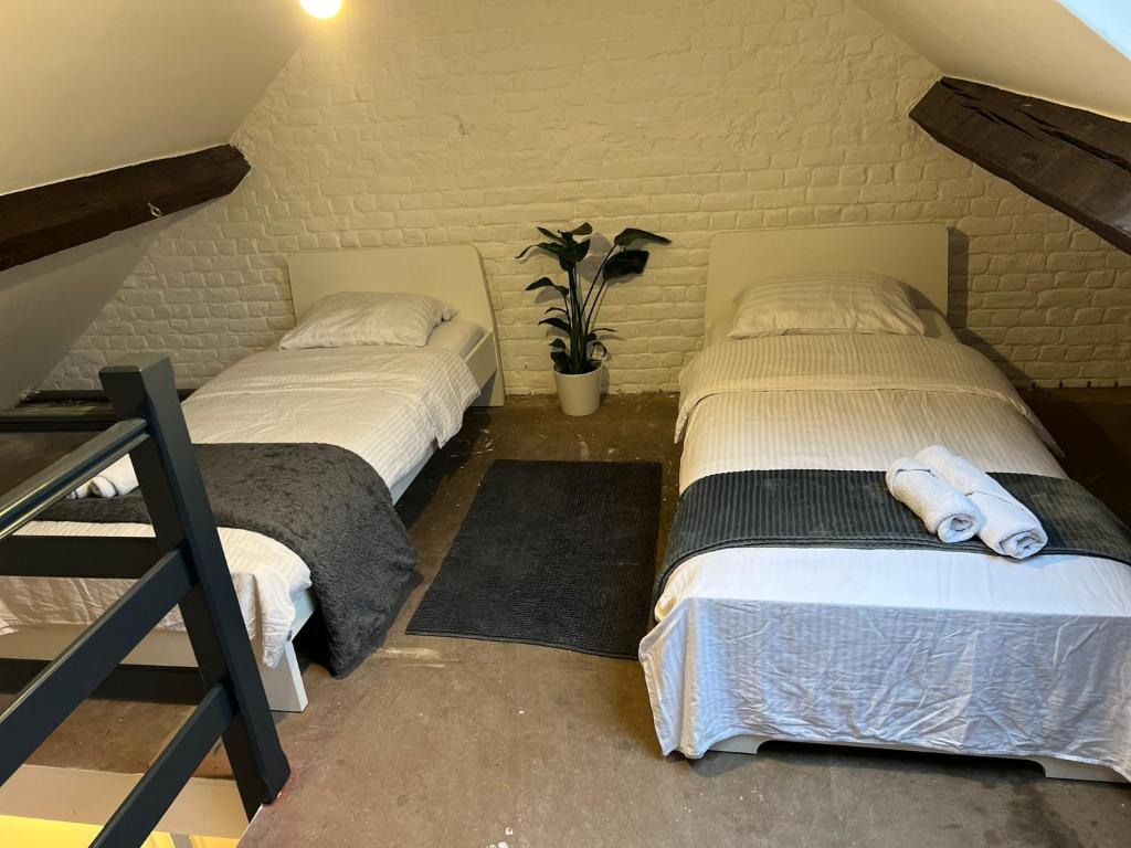 two beds sitting next to each other in a room at Quarto 1 in Brussels