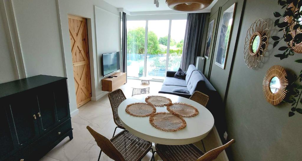 a living room with a white table and chairs at Kaya Apartament De Luxe 2 z basenem in Kołobrzeg
