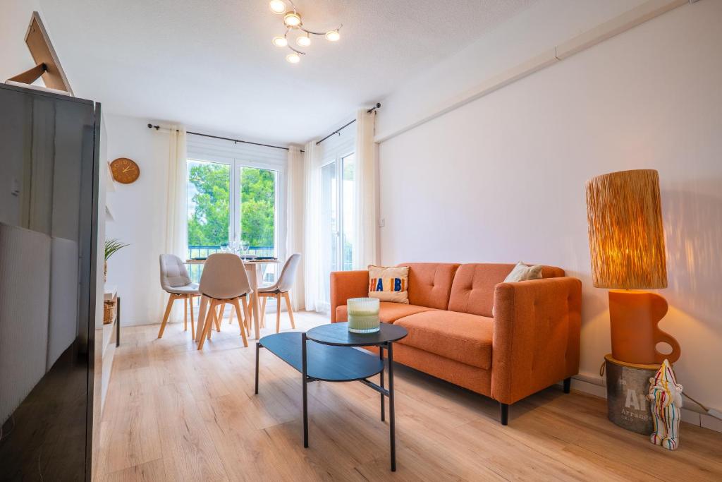 un salon avec un canapé et une table dans l'établissement Charmant appartement - Box Gourmande -parking -Clim, à Perpignan