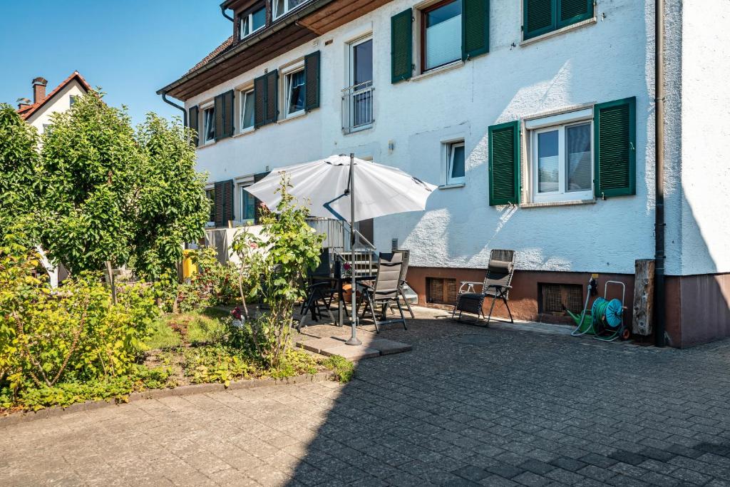 a house with a patio with an umbrella and chairs at Zum alten Wald in Zell am Harmersbach