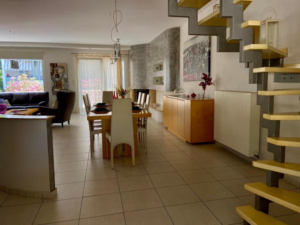 a kitchen and living room with a table and chairs at Diamond Maisonette in Kavála
