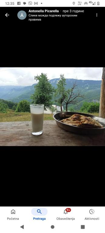 a glass of milk next to a bowl of food at Camp Apartmani Tara in Pljevlja