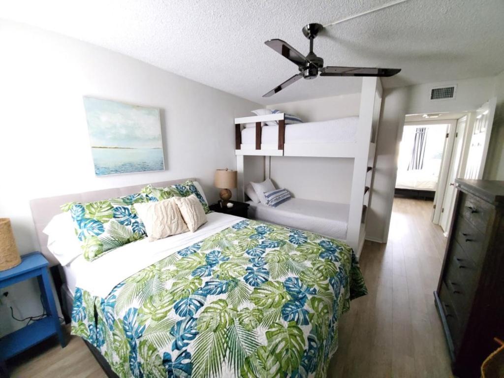 Un dormitorio con una cama y un ventilador de techo. en Ocean View 2 Bed, 2 bath, Steps to the Beach - Spanish Trace 240, en Coquina Gables
