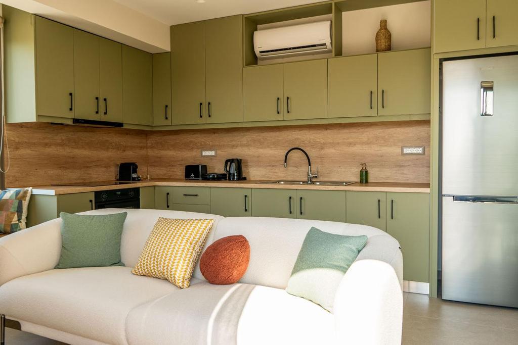 a living room with a white couch in a kitchen at Afali City Center apartments in Zakynthos Town
