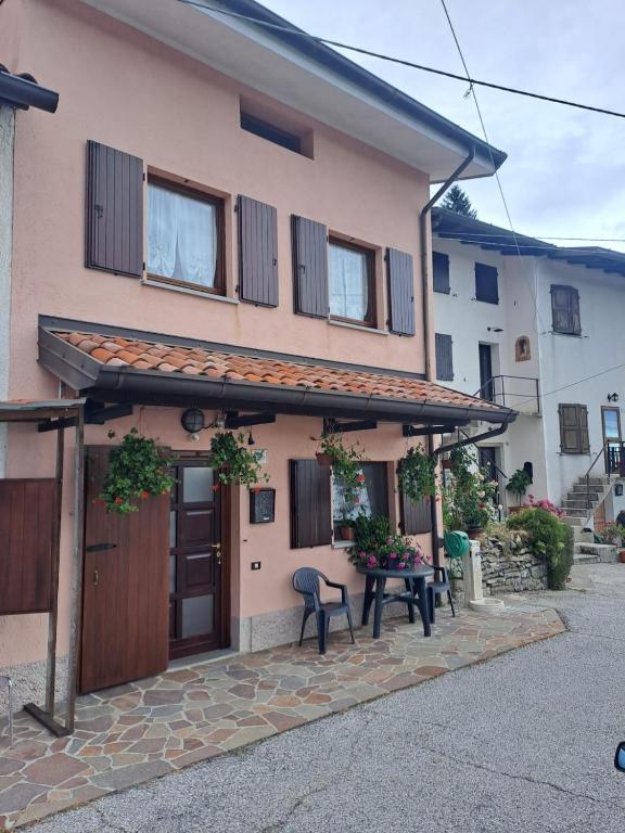 a house with a patio and a table in front of it at Casa vacanze Malinini in Savogna
