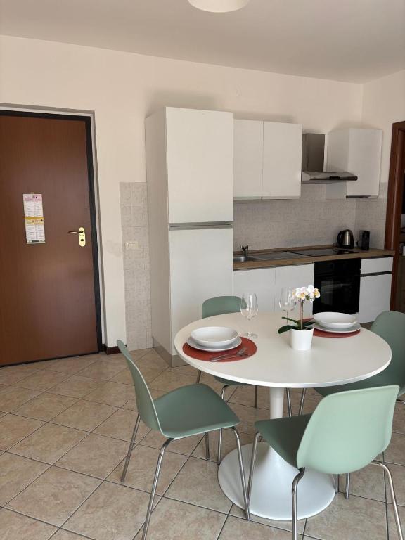 a kitchen with a white table and chairs and a kitchen at Appartamento vicino a Como e Milano in Mozzate