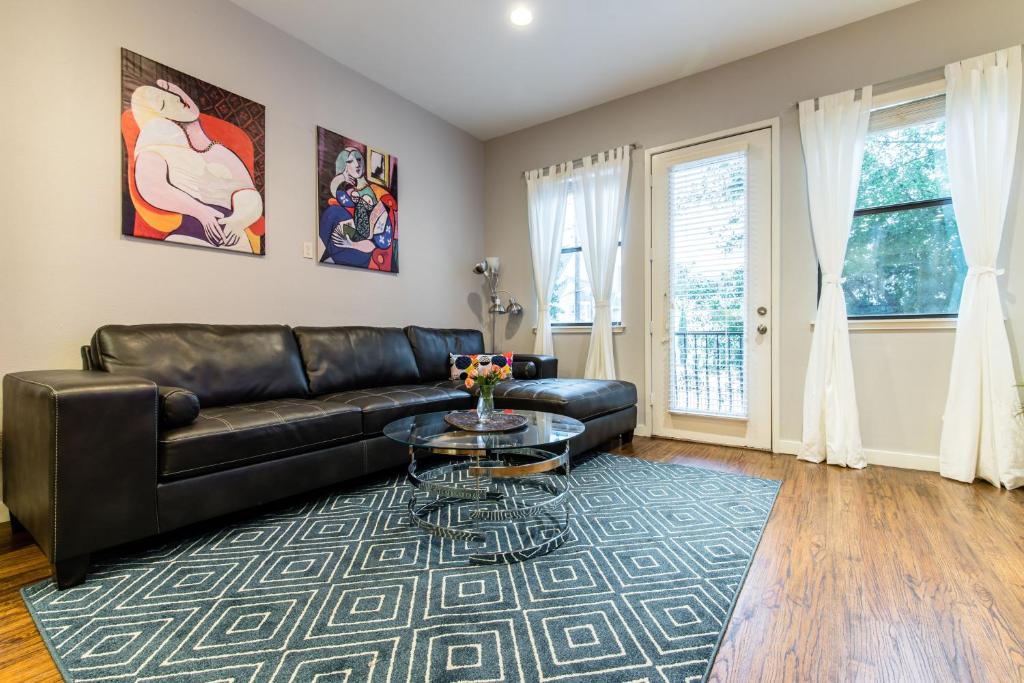 un salon avec un canapé en cuir et une table en verre dans l'établissement Victory Park Town Home Near Dallas Convention Center, à Dallas