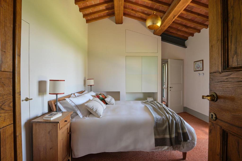 una camera da letto con un letto grande e un soffitto in legno di Sequerciani a Tatti