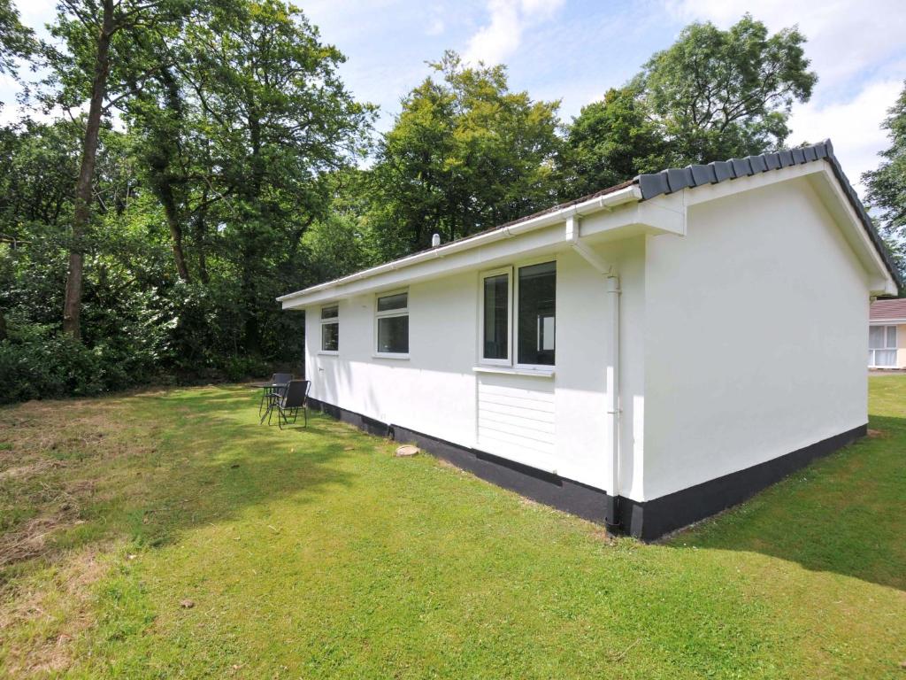a white modular home on a grassy field at 4 Rosecraddoc Lodge Holiday Bungalows in Liskeard