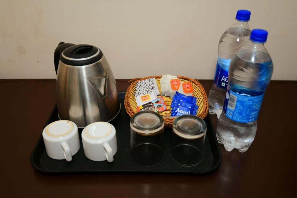 a tray with a coffee pot and two bottles of water at Hotel La Serene in Agra