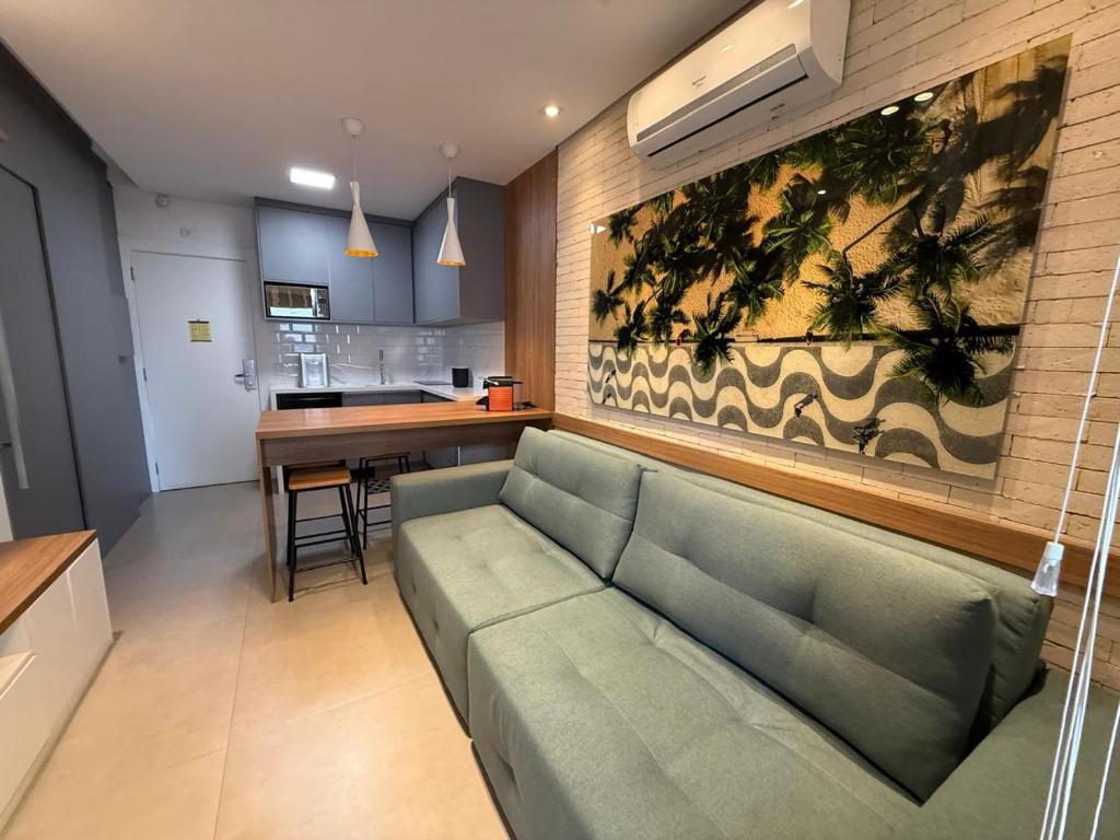 Una sala de estar con un sofá y una cocina. en Luxuoso Flat Itaim, en São Paulo